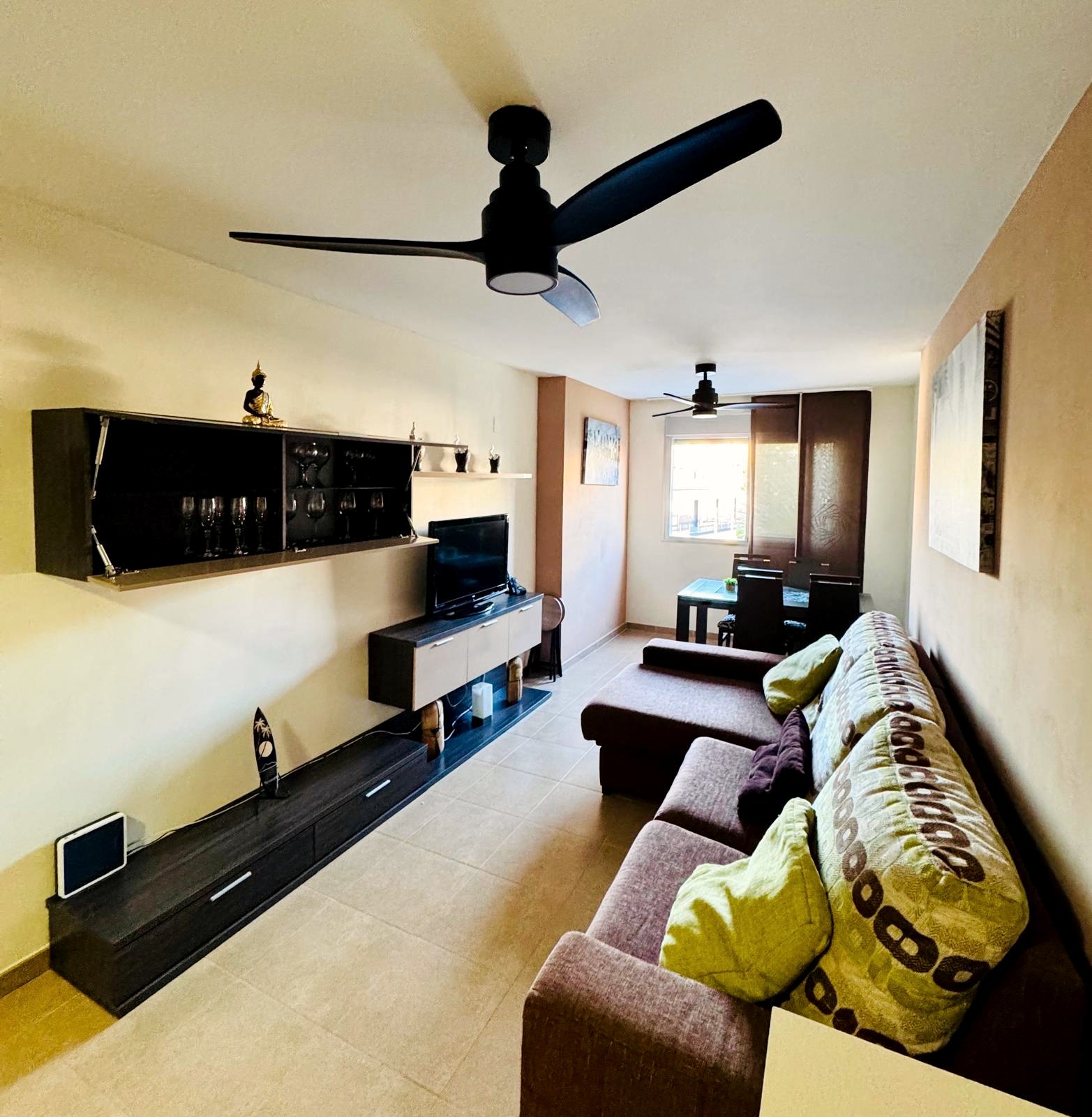 Salón con sofá y comedor de Leo Apartamentos El Clero