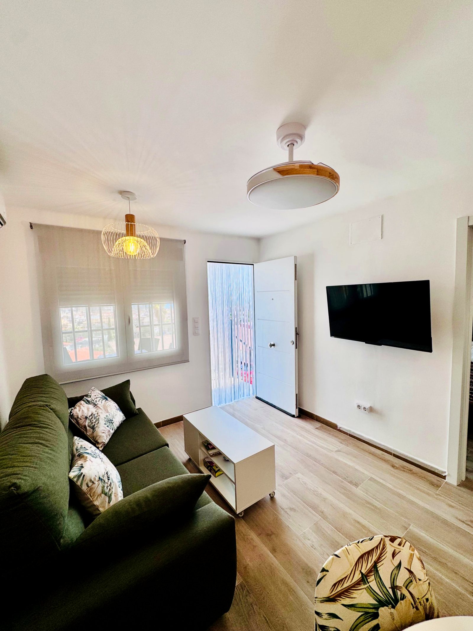 Zona de estar con sofá y TV en Leo Apartamentos La Cova