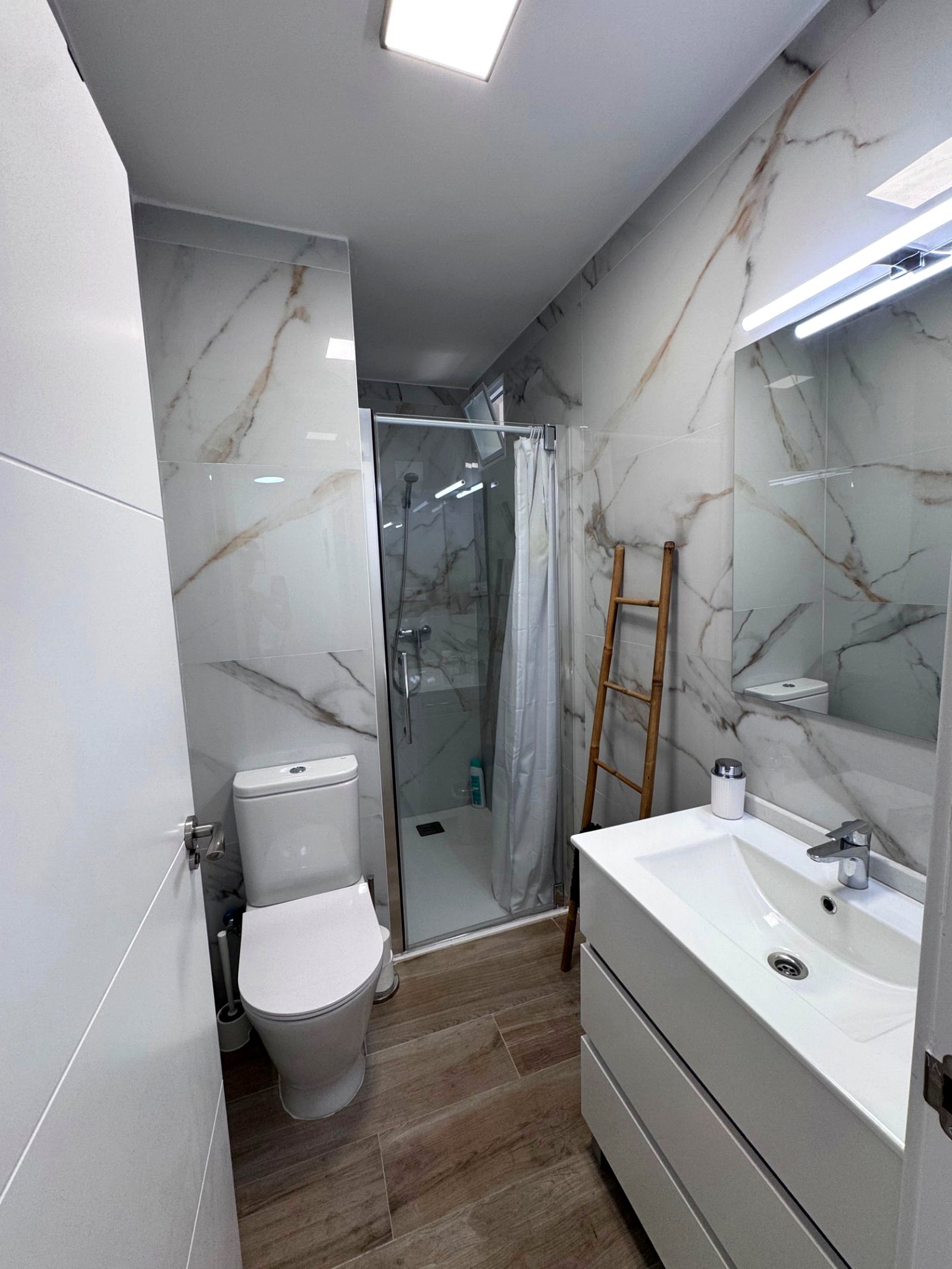 Baño con ducha y acabados en mármol en La Cova
