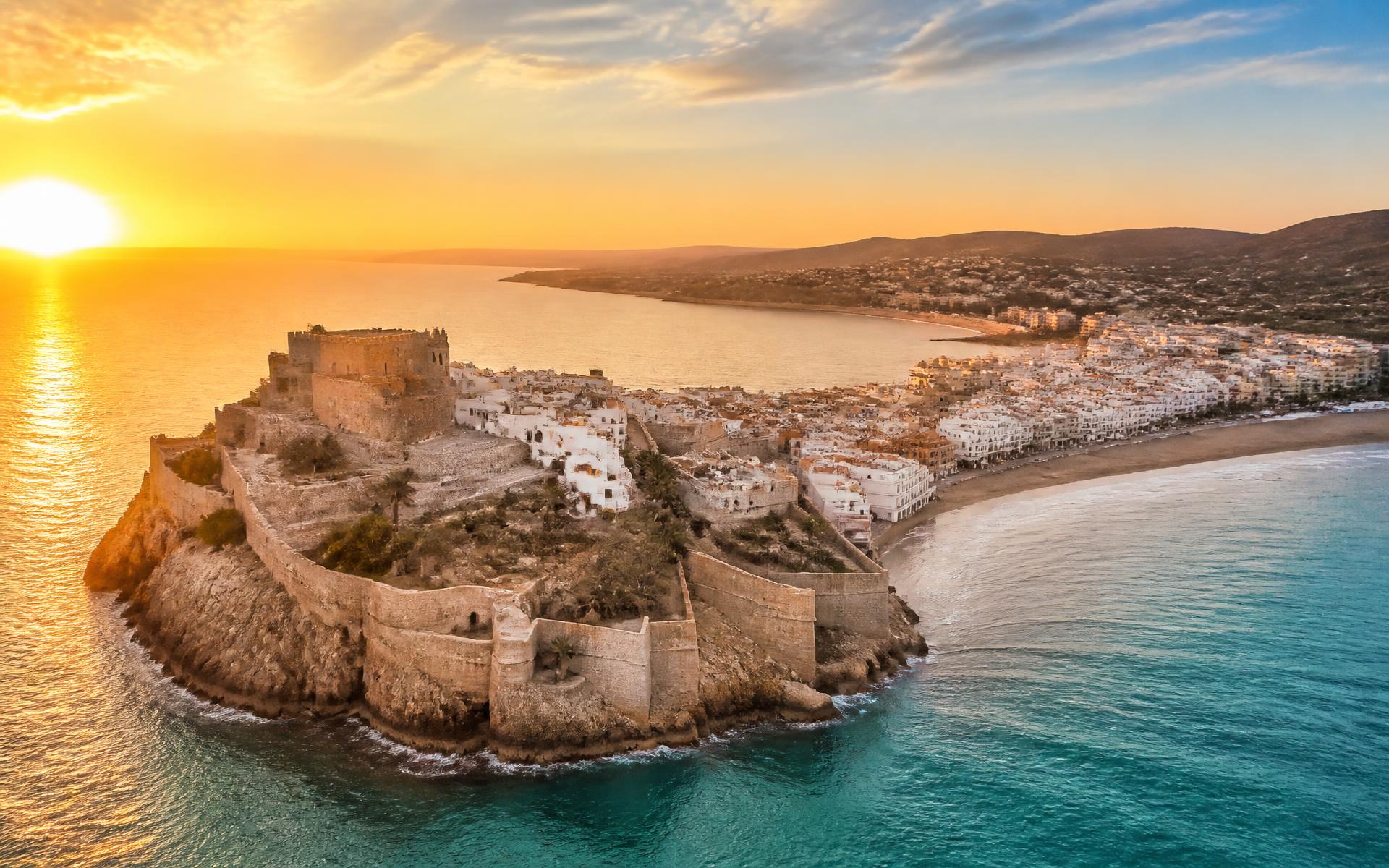 Vista aérea del castillo de Peñíscola al atardecer sobre el mar Mediterráneo